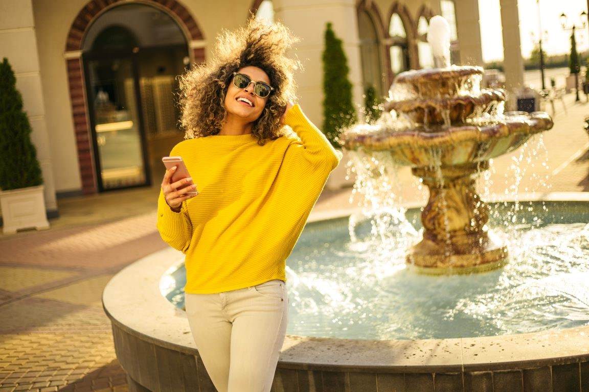 Woman with curly hair smiling in the sunshine