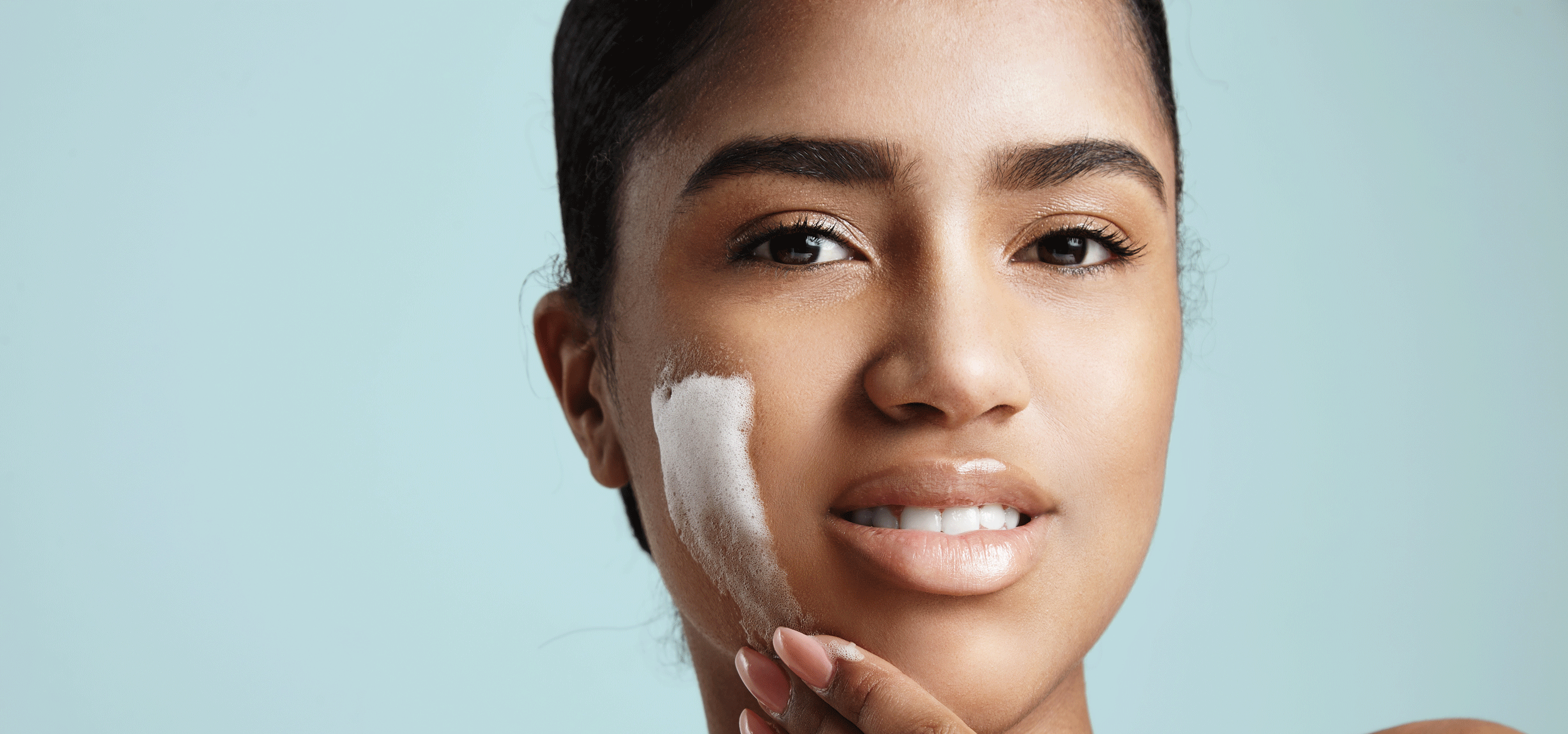 one brown woman with foam on her cheek